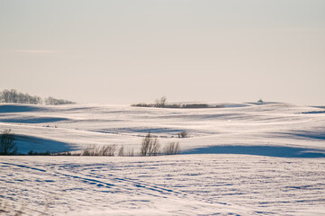 Zimowy krajobraz pagórki pokryte śniegiem na tle zimowego nieba