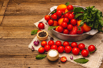 Assorted ripe multicolored tomatoes. Young garlic, fresh basil leaves, salt, spices