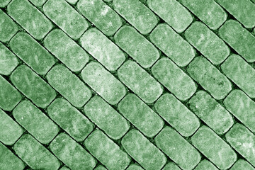 Green colored Stone walkway and cobbled road.