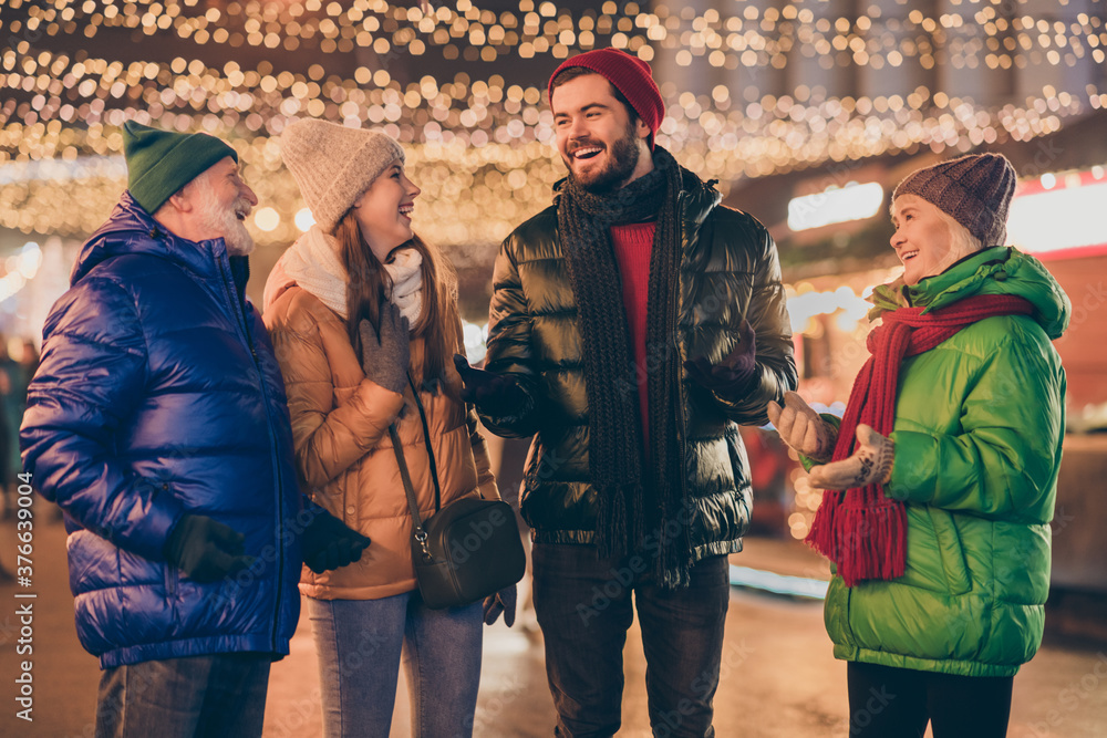 Poster Photo of full family four members x-mas meeting chatting laughing grandpa tell joke wear outerwear hat scarf coat gloves multi-generation night street park illumination fair outdoors