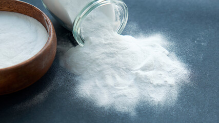 Glass bowl of baking soda. Spoonful of bicarbonate.