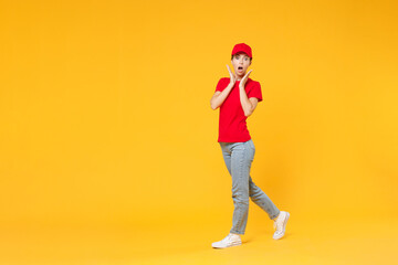 Fototapeta na wymiar Full length body delivery employee woman in red cap blank t-shirt uniform work courier in service during quarantine coronavirus covid-19 virus standing isolated on yellow background studio portrait.