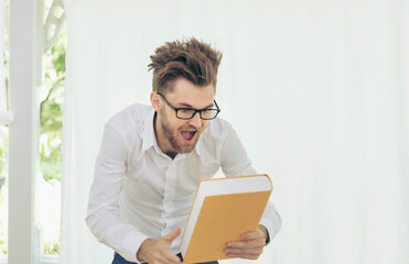 Caucasian man holding text book study hard surprise in content. education concept