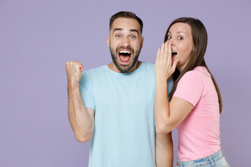 Excited screaming young couple two friends man woman 20s in blue pink t-shirts whispers gossip...