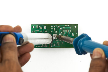 a man assembly a green of pcb (printed circuit board) with soldering iron. top view, isolated on white