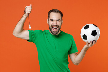 Laughing young man football fan in green t-shirt cheer up support favorite team with soccer ball...