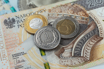 Polskie monety na tle banknotu dwieście złotych