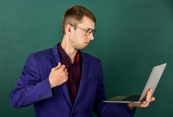 successful businessman in jacket. back to school. male with computer. knowledge ay concept. man looking smart in glasses. office clothes and fashion concept. ready for learning. School education