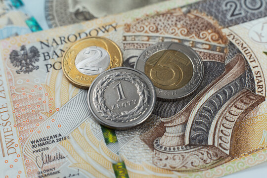 Polskie monety na tle banknotu dwieście złotych