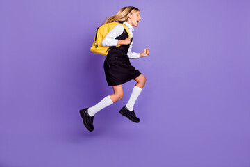 Fototapeta na wymiar Full length body size view of nice attractive cheerful purposeful energetic small little girl jumping running first lesson isolated bright vivid shine vibrant lilac violet purple color background