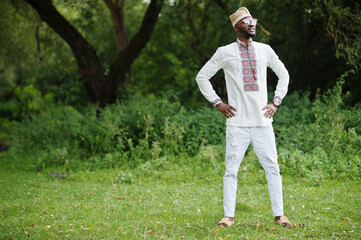 Portrait of african man in traditional clothes at park.