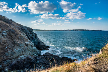 Water next to a mountain in Bulgaria. Blue sky with white clouds. Beautiful landscape