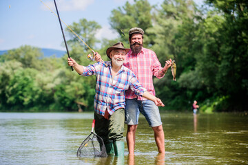 Adrenaline Hobby. Camping on the shore of lake. Big game fishing. friendship. two happy fisherman with fishing rod and net. Fly Fishing Time. hobby. hunting tourism. father and son fishing