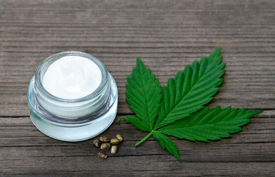 Cannabis cream in a jar with marijuana leaf and seeds on wooden background.CBD cosmetics,hemp extract,
herbal organic medicine, alternative or naturopathy concept.Selective focus.