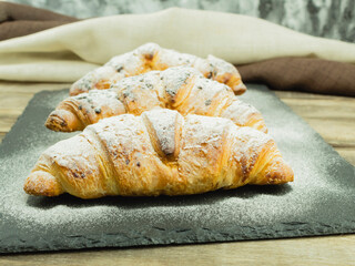 Fresh crispy croissants with chocolate filling and powdered sugar