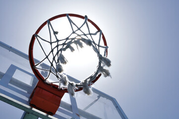 el sol pasa por el aro de la canasta de baloncesto © juanjose