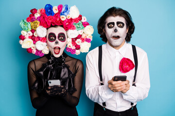 Obraz na płótnie Canvas Photo of spooky demon two people man lady hold telephones staring monster creatures banned scandal wear black dress death costume roses headband suspenders isolated blue color background