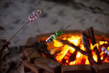 Delicious sweet hot marshmallow skewers on stick roasting over the bonfire