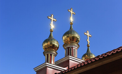 Three Orthodox crosses against the background of a blue summer sky