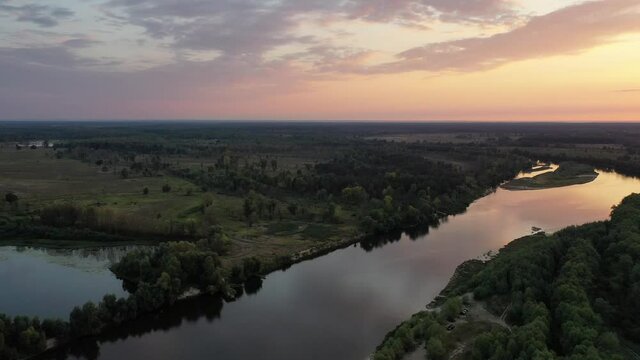 Aerial view. Beautiful sunset over the Desna river. Untouched nature by the river. River in the forest.