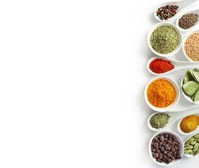 Top view of various spices in bowls and spoons isolated on white background. Copy space.