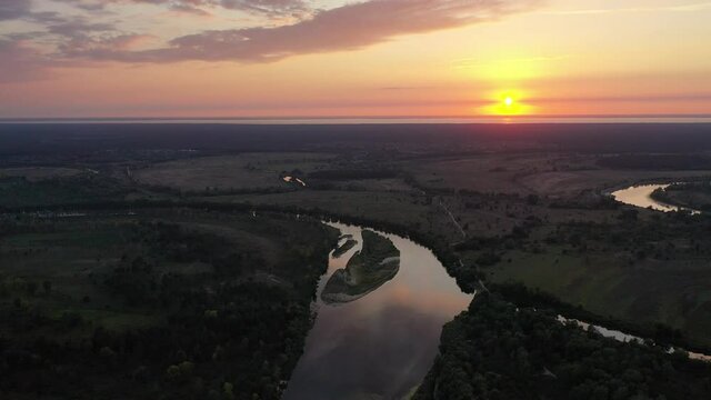 Aerial view. Beautiful sunset over the Desna river. Untouched nature by the river. River in the forest.