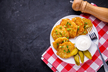 Delicious crispy potato pancakes on dark stone background