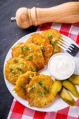 Delicious crispy potato pancakes on dark stone background