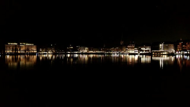 Illuminated buildings along Elbe River at night, Hamburg, Germany