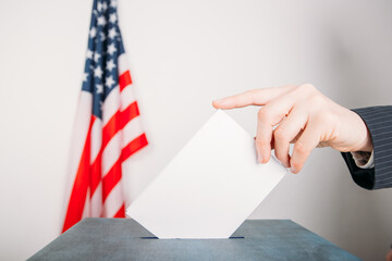 American voter putting ballot into voting box. Election concept. 