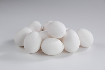 Mehrere weiße Eier, ein Haufen frischer Eier vor einem hellen Hintergrund