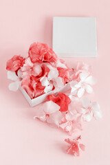 Gift box full of flowers  over a pink background