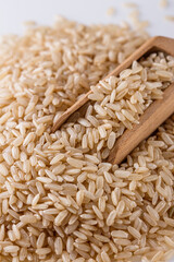 raw brown rice on white acrylic background