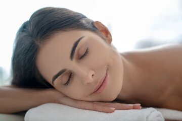 Obraz na płótnie Canvas Dark-haired woman lying down after beauty procedures