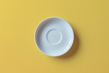 Empty white plate isolated on yellow background