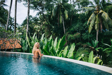 Positive young female resting in luxury pool