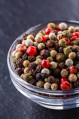 mix of peppercorns on a dark stone background