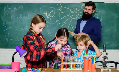 doing experiments with liquids in chemistry lab. chemistry lab. happy children & teacher. back to...