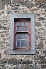 Fototapeta na wymiar Old Dirty Window with Stone Frame & Rough Textured Stone Wall 