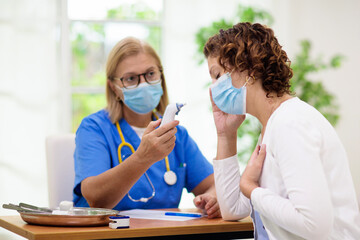 Doctor examining sick patient. Ill woman in clinic