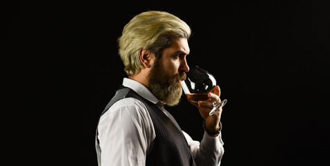 Confident sommelier. Male skilled sommelier estimates alcoholic drink. red wine in wineglasses. bearded man explore taste of wine in restaurant. Checking color and sediments of wine. Wine tasting