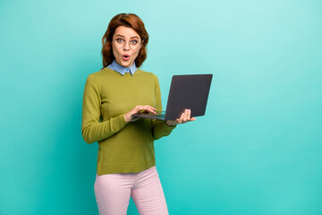 Portrait of her she nice attractive amazed cheerful cheery wavy-haired girl holding in hands laptop browsing web site isolated on bright vivid shine vibrant teal turquoise color background