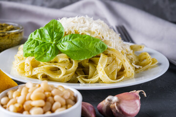 Delicious tagliatelle pasta with pesnto sauce on dark stone background