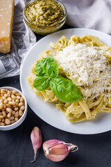 Delicious tagliatelle pasta with pesnto sauce on dark stone background