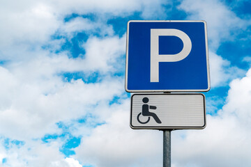 Disabled parking sign with clouds in the background