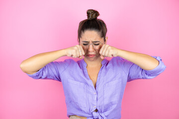 Young beautiful woman wearing glasses over isolated pink background depressed and worry for distress, crying angry and afraid. Sad expression.