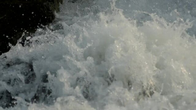 Detail of large flow of water in river. Detail of foams in river.