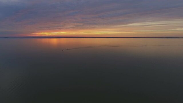 Motor Boat Yacht Sailing Through the Curonian Lagoon During Sunset. Aerial Pedestal Down