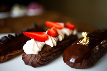Eclairs of different flavors set on a dark background for a restaurant menu