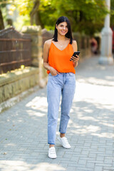 Portrait of beautiful smiling woman writing message in street